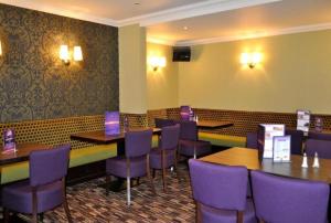 a dining room with tables and purple chairs at OYO Lochway Hotel in Dumbarton
