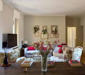 a living room with a couch and a table with flowers at Chez Papa Appartamenti - Chez Coco in Ravenna