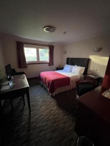 una camera d'albergo con letto e scrivania di OYO Lochway Hotel a Dumbarton