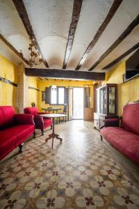 a living room with red couches and a table at Casa Museo RAKKANA - En el Centro de Requena in Requena