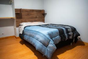 Bett in einem Zimmer mit einem Kopfteil aus Holz in der Unterkunft Hospedaje Tel Aviv in Ayacucho