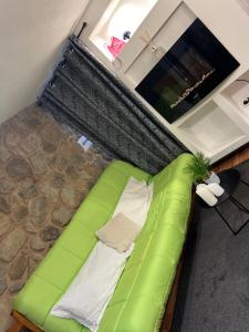 un divano verde per terra in una stanza di La Maison Dell'Amour a Boville Ernica