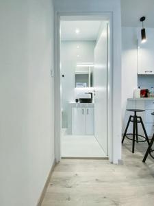 a white kitchen with a door leading into a room at Syntagma square, 60sqm Platinum suite in Athens