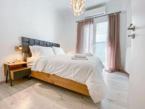 a white bedroom with a large bed and a window at Syntagma square, 60sqm Platinum suite in Athens