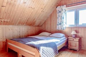 sypialnia z łóżkiem w drewnianym domku w obiekcie Domki Morena - Rodzinne Domki Blisko Plaży w Karwii