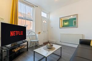 a living room with a tv and a couch at STAYZED N2 - Modern, Colourful NG7 Home, Next To City Centre, Lots Of Amenities, Ideal for Long & Short Stays. in Nottingham