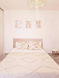 a white bedroom with a large bed with a rug at Bed & Breakfast - Entre Paris & Disneyland in Roissy-en-Brie