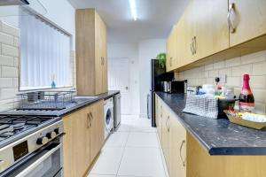 a kitchen with wooden cabinets and a stove top oven at Merrivale House in Birmingham