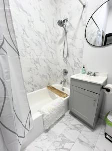 a bathroom with a tub and a sink and a mirror at Studio in Union Square in New York