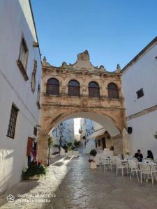 ein Gebäude mit einem Bogen mit Tischen und Stühlen in der Unterkunft Antica Dimora Giusy in Ostuni