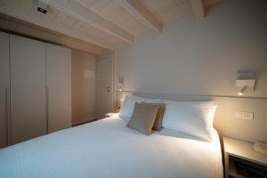 - une chambre avec un grand lit blanc et des oreillers blancs dans l'établissement Ca Marièt casa vacanze, à Chiavenna
