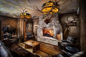 sala de estar con chimenea de piedra y muebles de cuero en Bass Pro Shops Angler's Lodge en Hollister