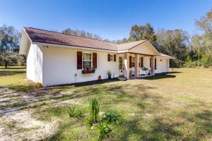 a small white house with a large yard at Gas Grill and Fire Pit Peaceful Dunnellon Home! in Dunnellon