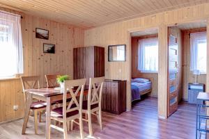 a dining room with a table and a bedroom at Domki Morena - Rodzinne Domki Blisko Plaży in Karwia