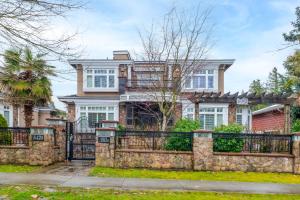 una grande casa in mattoni con una recinzione in pietra di Oakridge Luxury Homestay a Vancouver