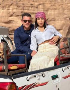 Un hombre y una mujer sentados en la parte trasera de un camión. en Wadi Rum Meteor camp en Wadi Rum