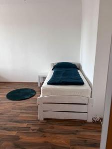 a white bed in a room with a wooden floor at Ruhige Wohnung in Schwechat nähe Flughafen in Schwechat