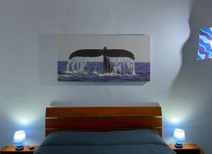 a bedroom with a bed and a picture of a whale at Casa Vacanze Oceano in Livorno