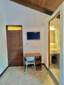 Cette chambre comprend une table en bois, une chaise et un lavabo. dans l'établissement Hotel Citadin Z10, à Guatemala