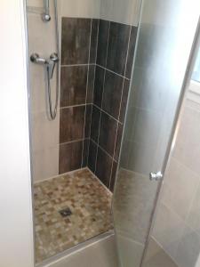een douche met een glazen deur in de badkamer bij Gite Jours tranquilles in Pleumeur-Bodou