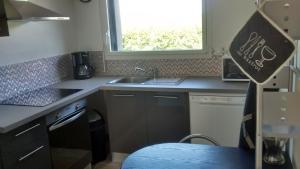 une cuisine avec un évier et une fenêtre dans l'établissement Gite Jours tranquilles, à Pleumeur-Bodou