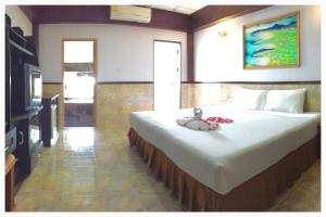 1 dormitorio con 1 cama grande y TV en Kata Palace Phuket, en Kata Beach