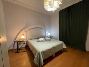 een slaapkamer met een bed en een groen gordijn bij Alteur Stays in Genua