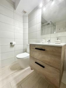 uma casa de banho branca com um WC e um lavatório em Apartamento Playa y Sol em Calpe