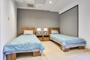 马尔萨斯卡拉Holiday Home in Marsaskala的配有蓝色毯子的客房内的两张床