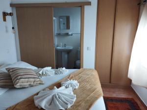 a bedroom with a bed with towels on it at Casa Sarguito in Sagres