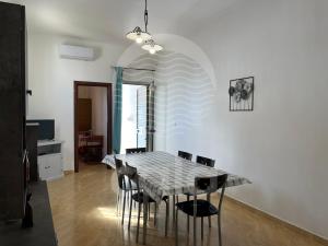 una sala da pranzo con tavolo e sedie di Casa del Marinaio - Fronte Mare a Porto Cesareo