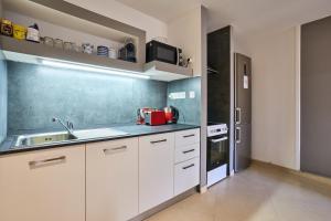 a kitchen with white cabinets and a sink at Holiday Home in Marsaskala in Marsaskala