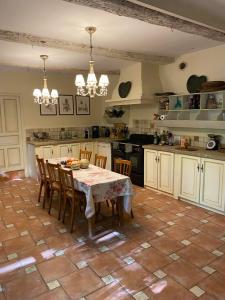 une cuisine avec une table et des chaises dans une cuisine dans l'établissement La Combe de Lamaron, à Bollène