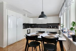 a white kitchen with a table and chairs at Guestly Homes - Homely 2BR Apartment with 3 Beds in Boden