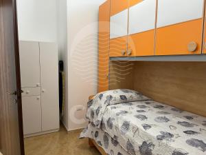 una camera con letto a baldacchino arancione e bianco di Casa del Marinaio - Fronte Mare a Porto Cesareo
