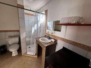 a bathroom with a sink and a toilet and a mirror at Whale Hill in Puerto Peñasco