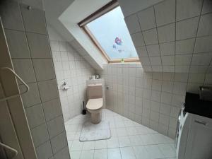 a bathroom with a toilet and a window at MM Zimmervermietung Messenähe Hannover in Laatzen