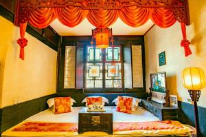 a bedroom with two beds and a window with red curtains at Pingyao Ji Family Courtyard Inn in Pingyao