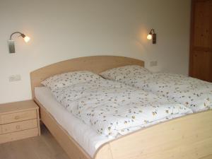 - une chambre avec un lit et une tête de lit en bois dans l'établissement Rebhof Kaltern, à Caldaro
