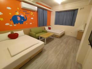 a small room with a bed and a couch at Penghu Le You You Homestay in Magong