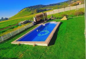 an overhead view of a swimming pool in a grass field at VILLA BILBILIS con piscina privada, barbacoa y parking in Linares