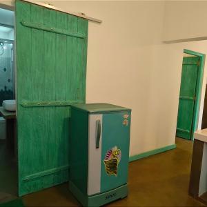 ein alter grüner Kühlschrank neben einer grünen Tür in der Unterkunft Mahi-Mahi Villa in Dikwella