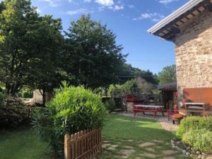 um jardim com uma cerca de madeira e uma mesa de piquenique em Casa Borc di Nelle em Attimis