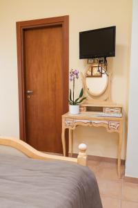 a bedroom with a bed and a television on a table at Tenuta Tralice in Ruviano