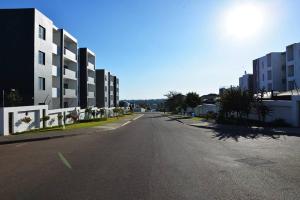 an empty street in a city with tall buildings at The Mansioners Apartment in Midrand