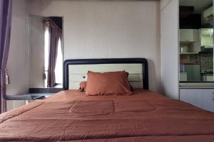 1 dormitorio con 1 cama grande con manta roja en Apt Sunter Park View Studio Murah with Pool & Wifi, en Yakarta