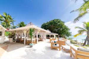 - un kiosque avec des chaises et des tables sur la plage dans l'établissement Village Pierre & Vacances Sainte Anne, à Sainte-Anne