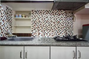 cocina con fregadero y pared de azulejos en Apt Sunter Park View Studio Murah with Pool & Wifi, en Yakarta