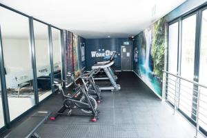 a gym with bikes parked in a room with windows at The Mansioners Apartment in Midrand