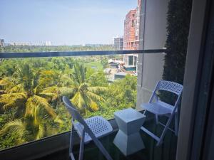 a balcony with two chairs and a view of the city at Evara - Fully Air-Conditioned Luxury Apartment in Trivandrum